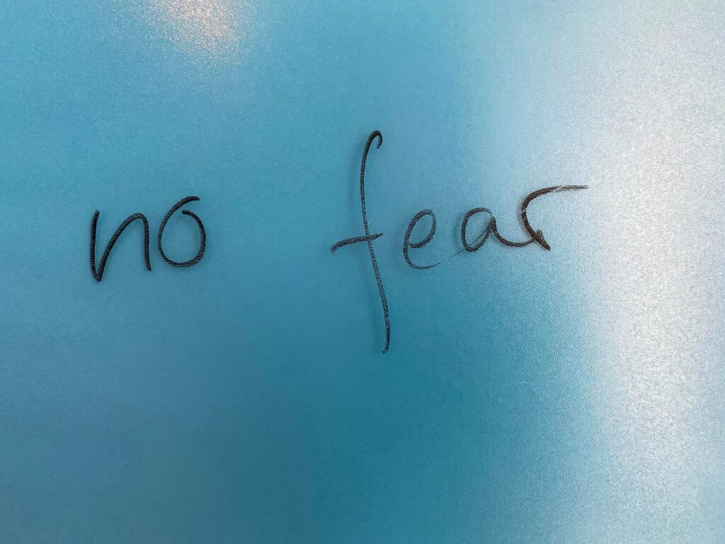 A close up of the words no fear written in black ink.