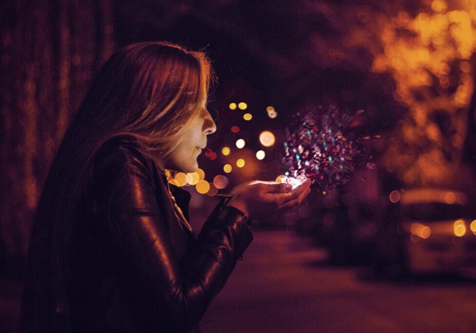 A woman holding a sparkler in her hand.